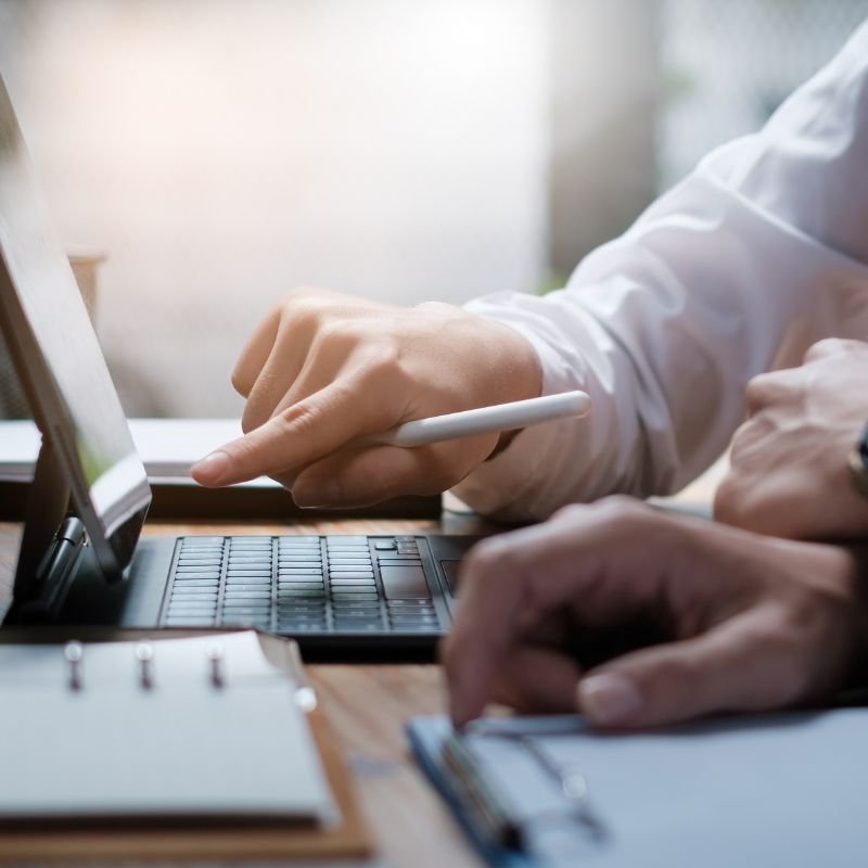 Finance professional reviewing bookkeeping records on a laptop